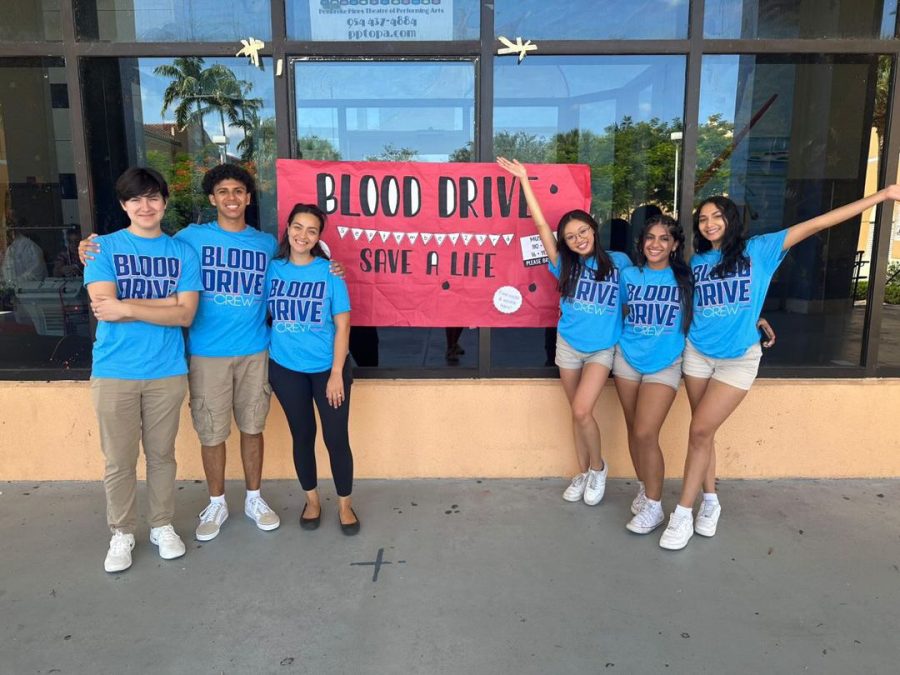 Key Club president, Trinity Tang (right from center), and sponsor, Ms. Taylor (left from center), smile alongside the other officers after a successful day of donating blood. Like the banner says, Key Club did indeed save lives through their first of many Blood Drives.