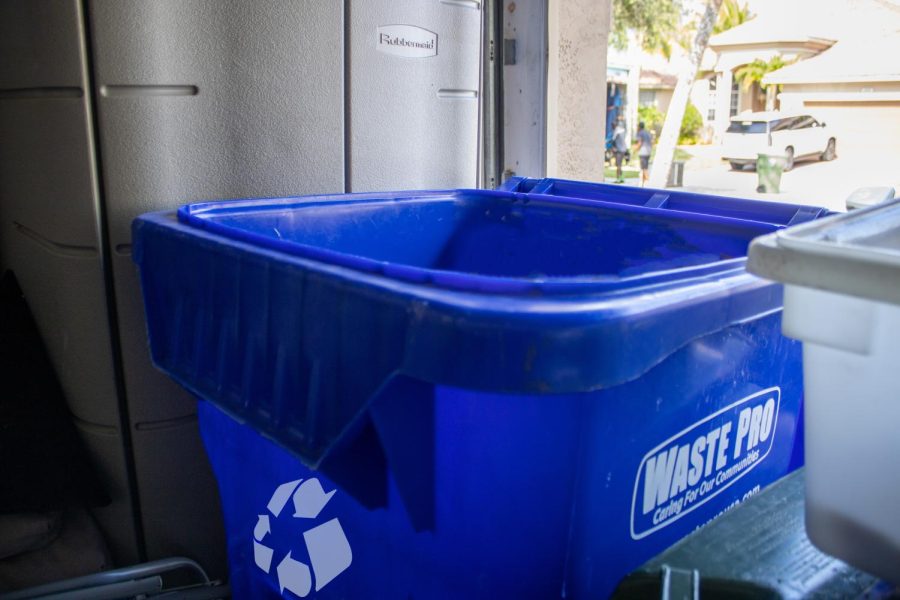 A student’s recycling bin rests tucked into a dark corner of their garage. Outside, and in the background, its green counterpart becomes Pembroke Pines’s new “Waste Pro”. 