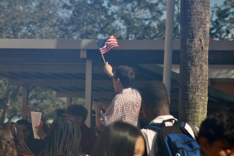 A student waves the American flag while peers below emphatically recite a part of the Constitution. The defining document was read aloud as a part of Charter’s tradition of Constitution day, a day that recognizes the freedoms of our people and the duties of our government. 
