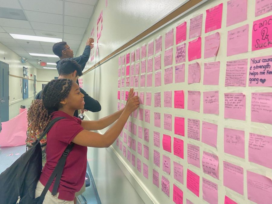 With a smile, Relay for Life members paste the pink sticky notes of students who offered their kind words to patients and survivors of breast cancer. Honoring the month of Breast Cancer Awareness, Relay for Life decided to create a mural out of the encouraging messages of students around campus.