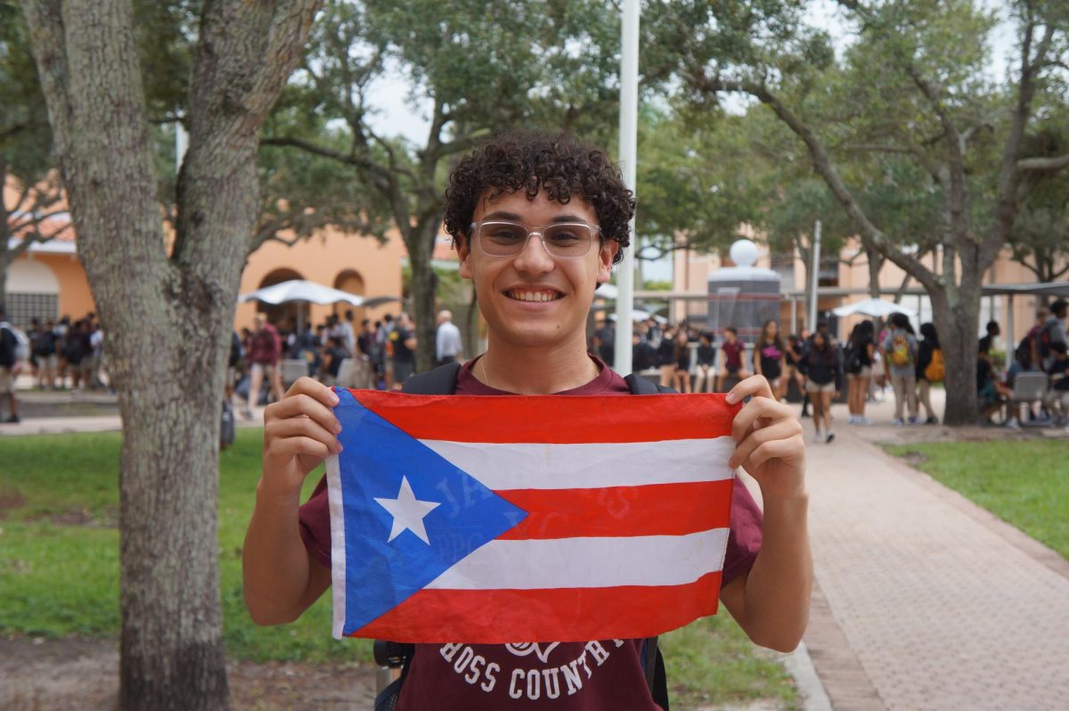 Armando Ayala stands in front of Charter’s fountain, holding the Puerto Rican flag to celebrate his heritage. Hispanic culture and heritage is a central part of life for many PPCHS students, with over 48% of the student population being of hispanic descent. 
