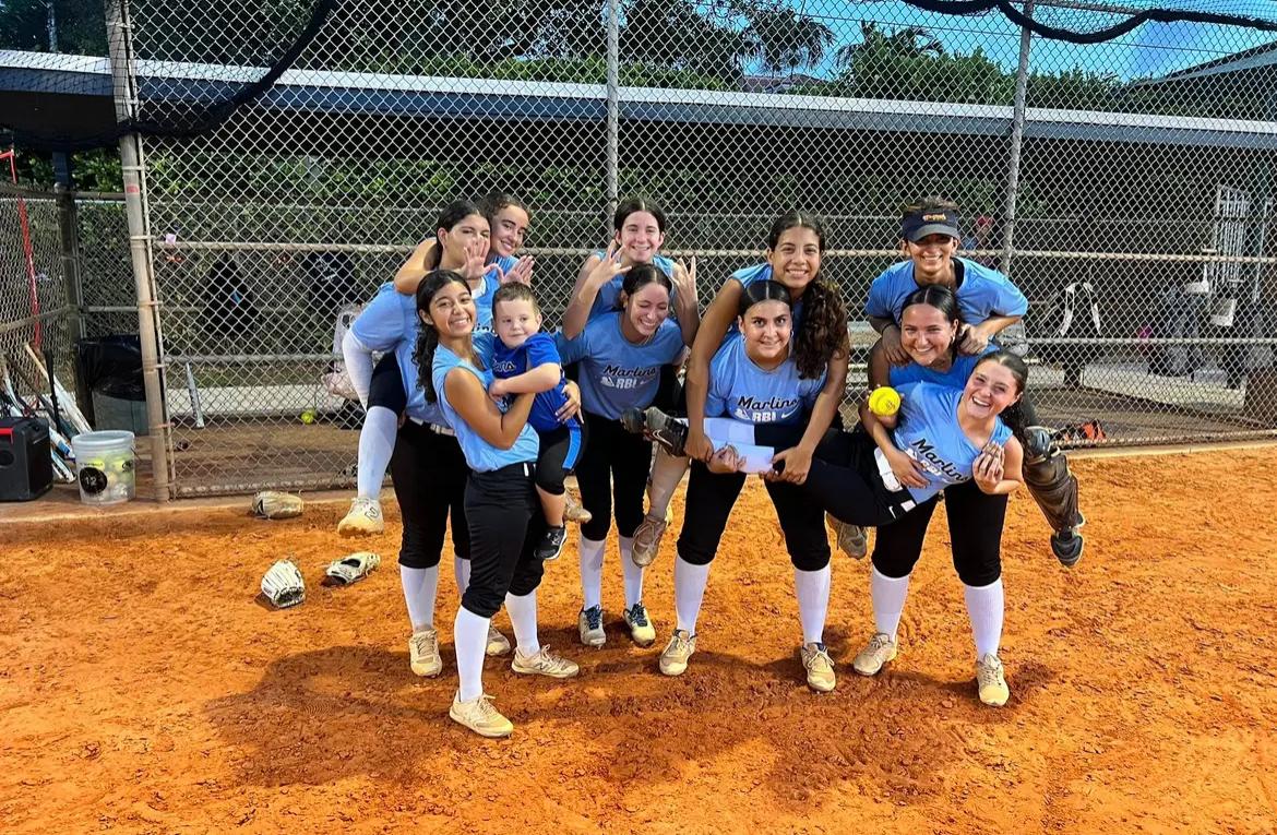 Daisy Ferguson and her team celebrating with their pitcher after she hit her season high of 100 strikeouts.