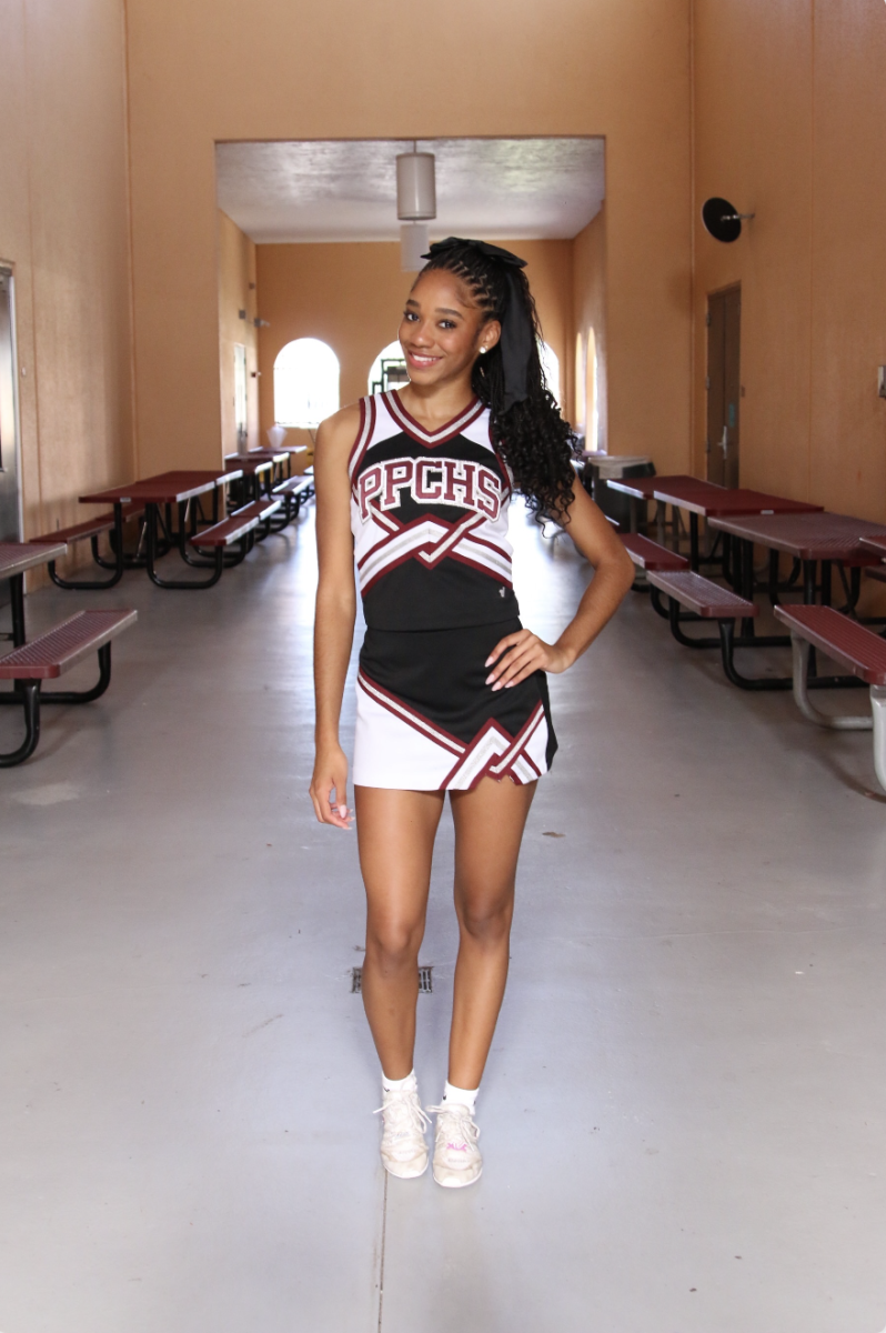 Victoria Eason posing in front of the camera with her cheer uniform on, highlighting her journey and strength of commitment. 