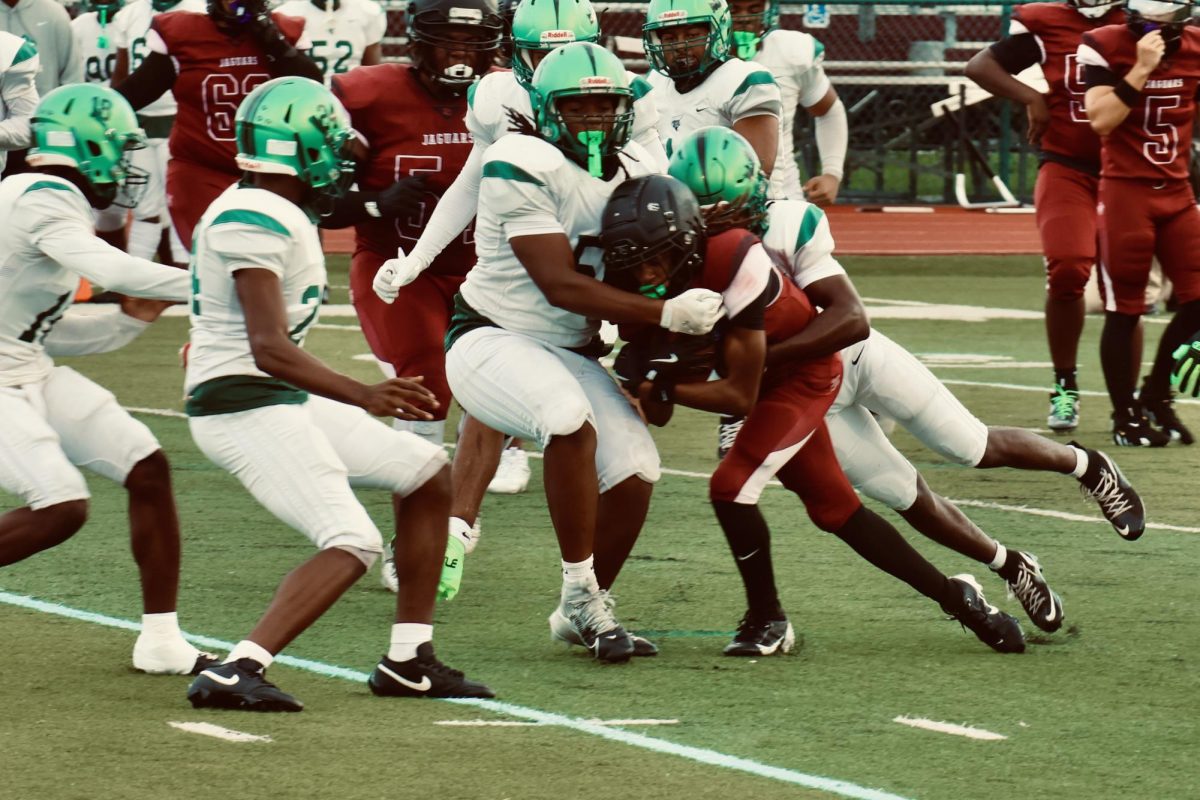 Jaguar's wide receiver Omari Colbourne attempting to escape the tackle after quarterback Trenton Beesing threw the ball to him.
