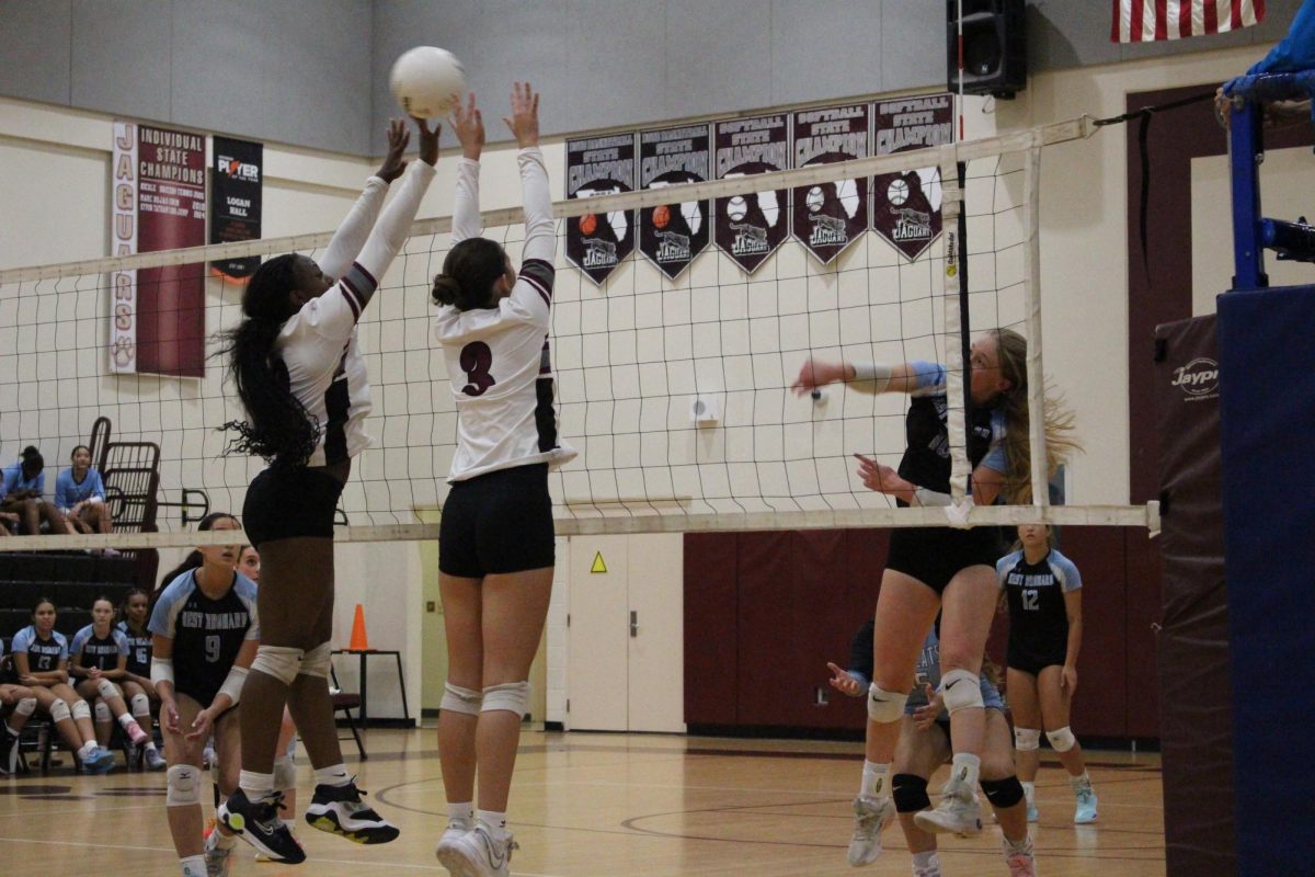 Junior Brielle Mckenzie [left] and Senior Daniela Camacho [right] blocking the spike from the West Broward High School Volleyball team.