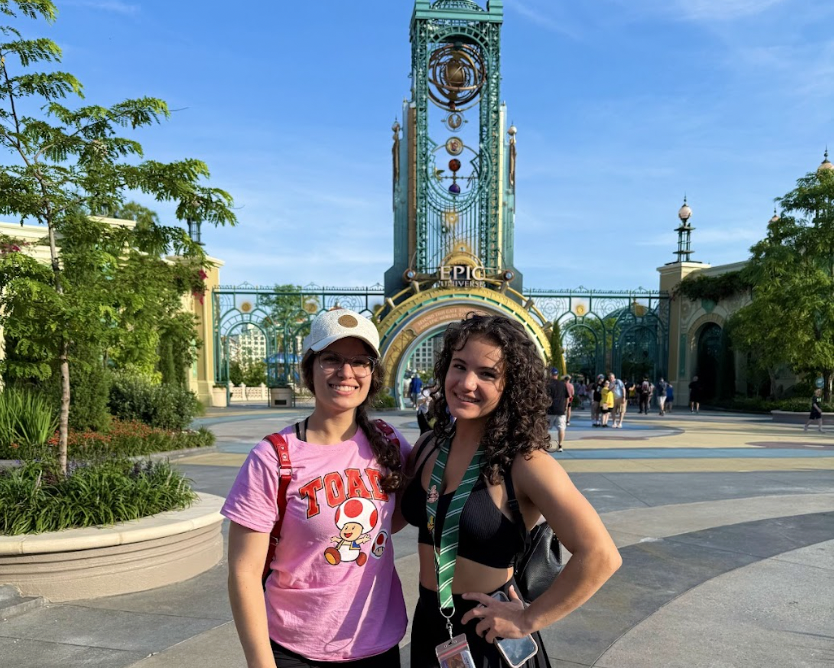Amanda Quintela at Epic Universe smiling with her sister awaiting the future excitement.