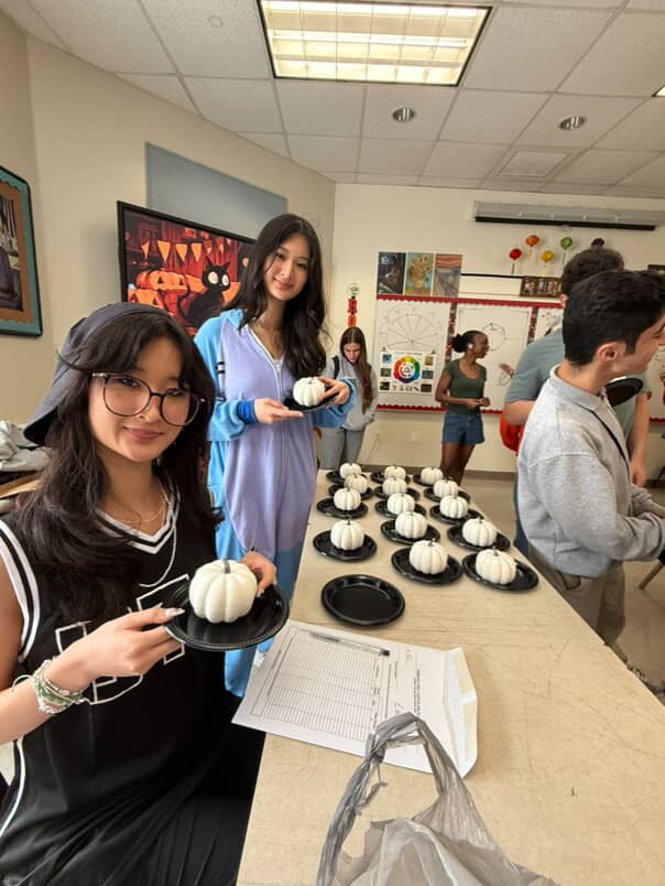 Seniors and board members of NAHS grabbing their beautifully white painted pumpkins after
waiting for the first layer to dry. In the front is Treasurer of NAHS Meghan Chin and in the back
is Historian of NAHS Brianna Chin.