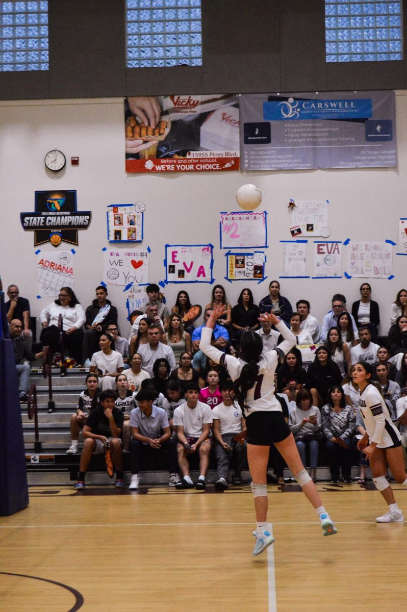 Senior Lila Peterseil setting the ball to Senior Alessandra Moreno in attempt to spike the ball to the other team and score the point to win the set.