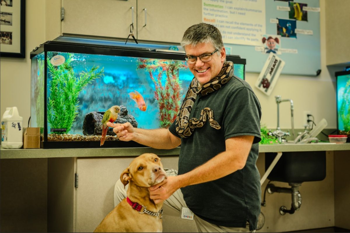 PPCHS teacher, Tyler Kapela, with his dog Amber, parrot Perry, and snake