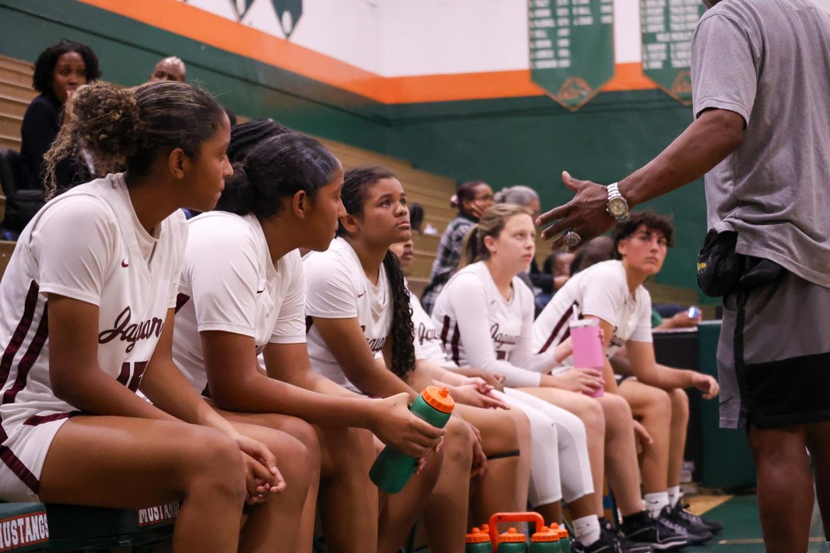 The Lady Jags Basketball team along the sideline during a game last season as their coach speaks to them about the main focus of the game and the season overall: dominate.