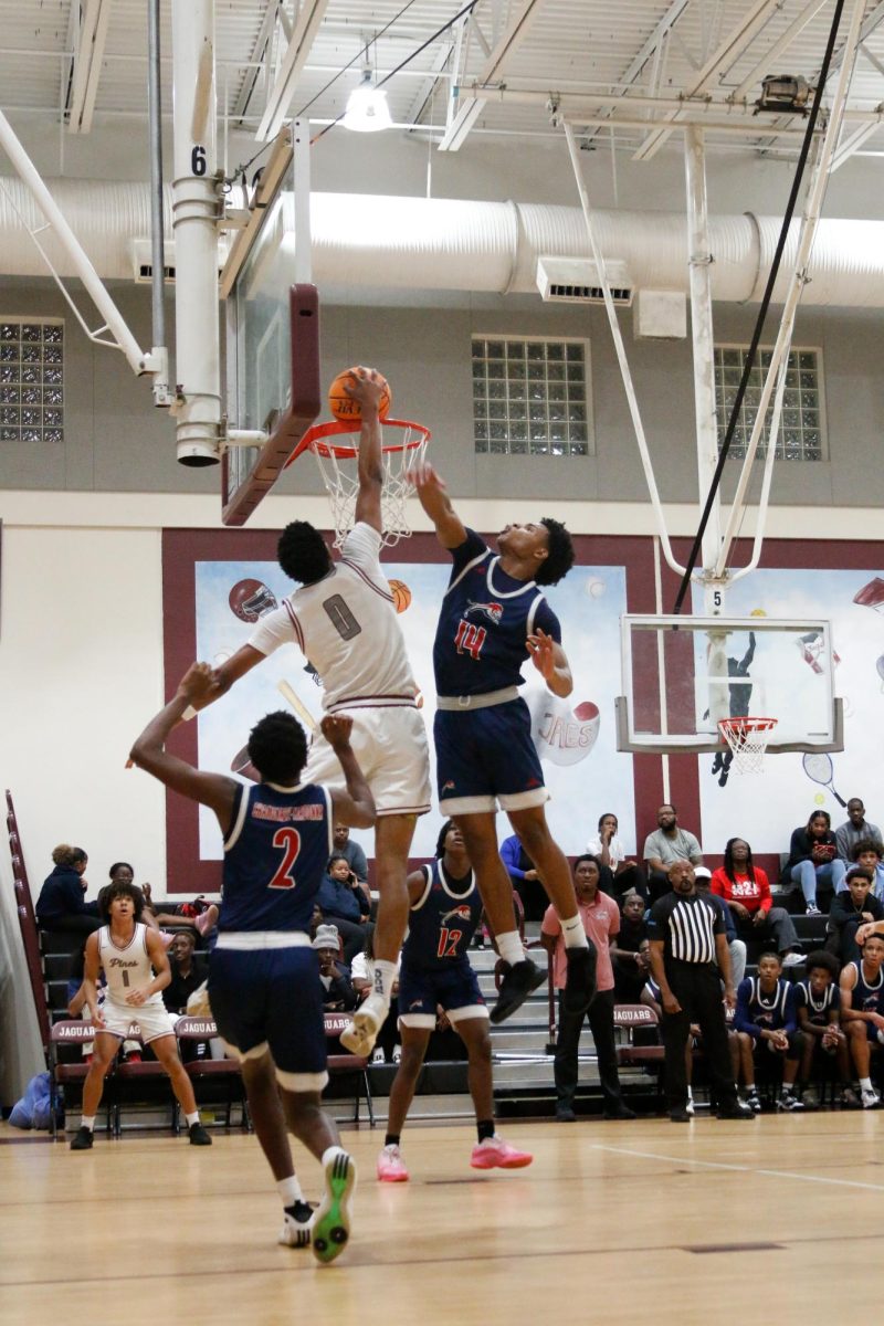 Junior Anthony Walcott #0 as dunks the ball at the Varsity basketball team's home opener helping the Jaguars maintain their lead.