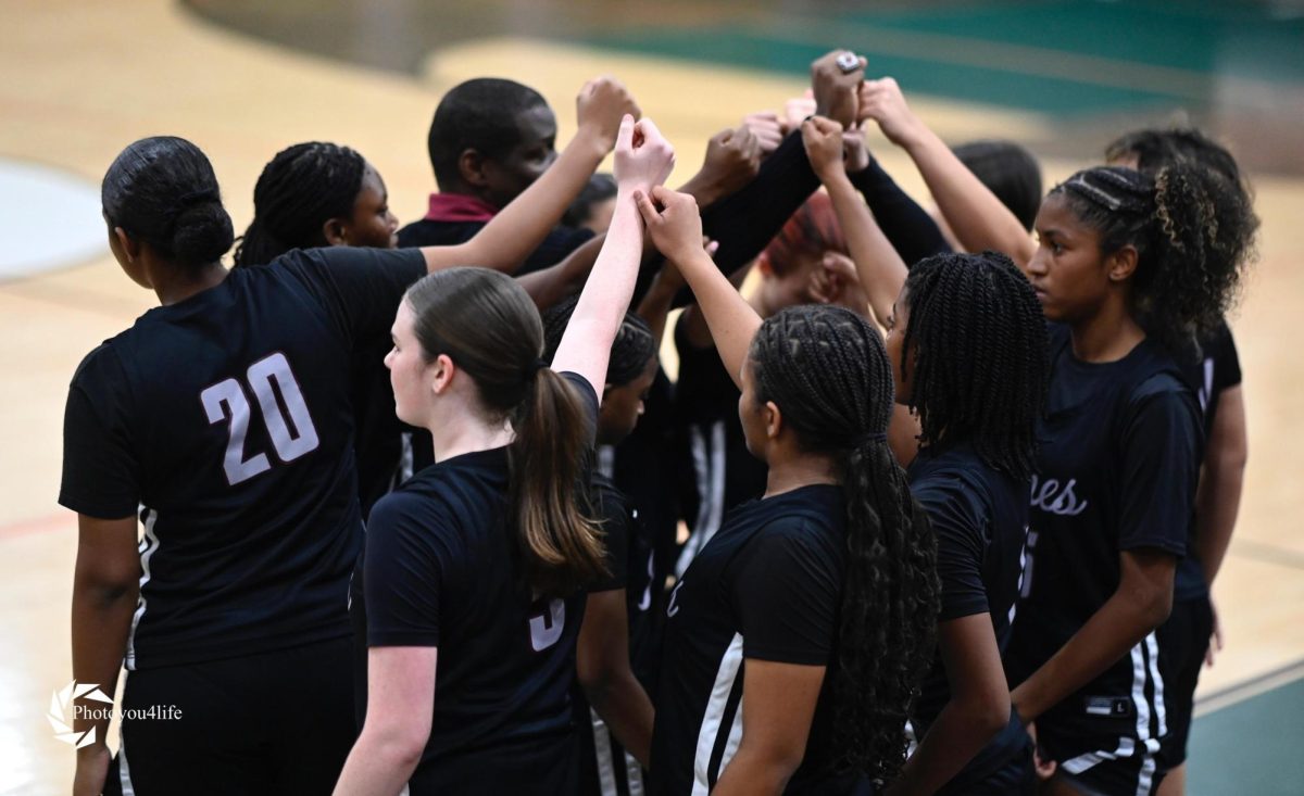 Pembroke Pines Charter High School girls basketball team putting their hands together unifying their work and efforts, showing off that they are just as strong as boys can be.