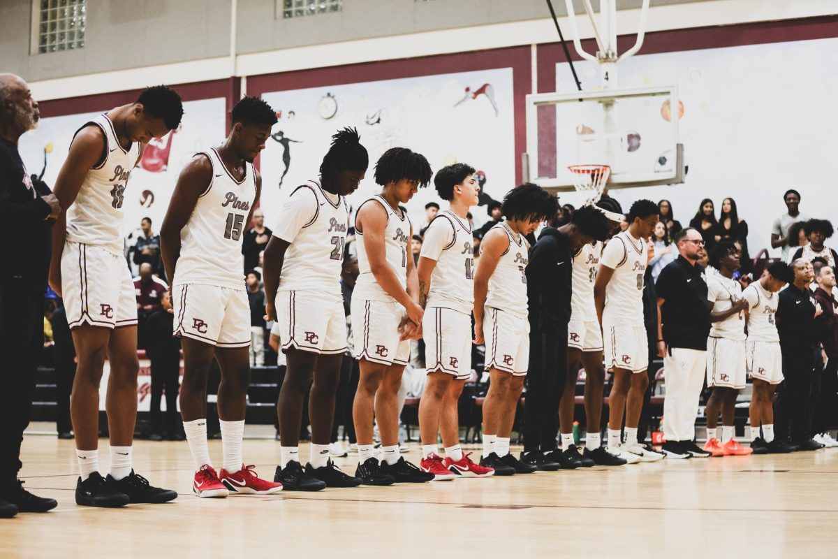 The Jaguars varsity basketball team alongside each other as the star-spangled banner plays prior to tipping off their season against Chaminade Madonna College Prep High School.