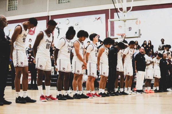 The Jaguars varsity basketball team alongside each other as the star-spangled banner plays prior to tipping off their season against Chaminade Madonna College Prep High School.