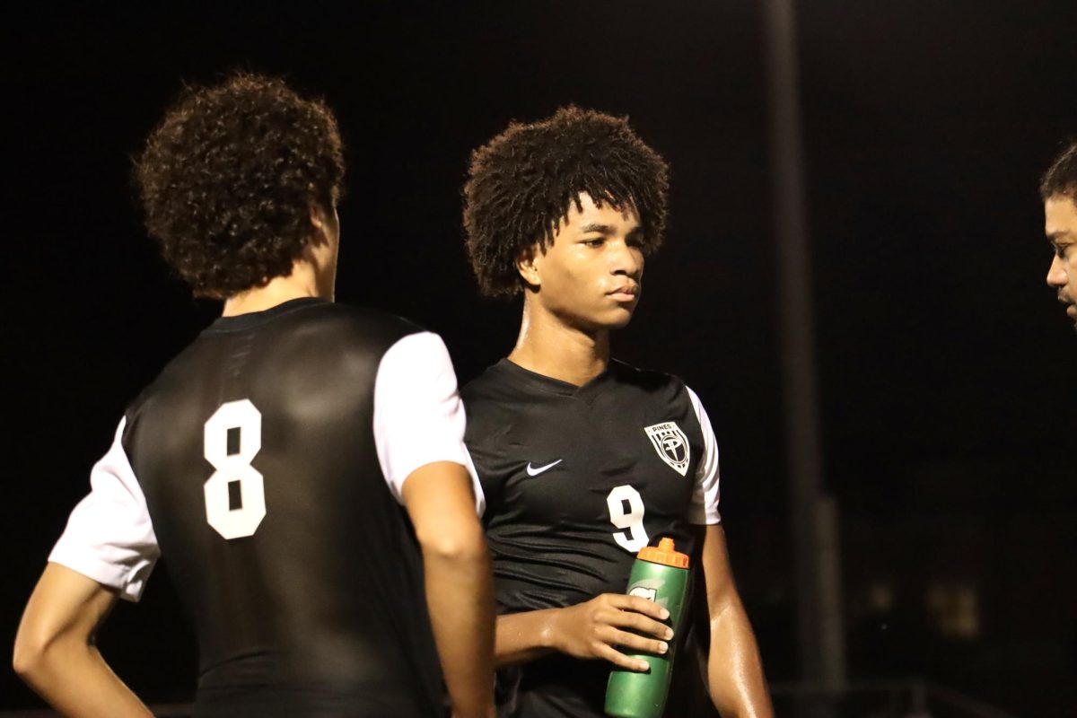 The Jaguars soccer players as they speak to their coach after the first quarter of their game as they are locked in.