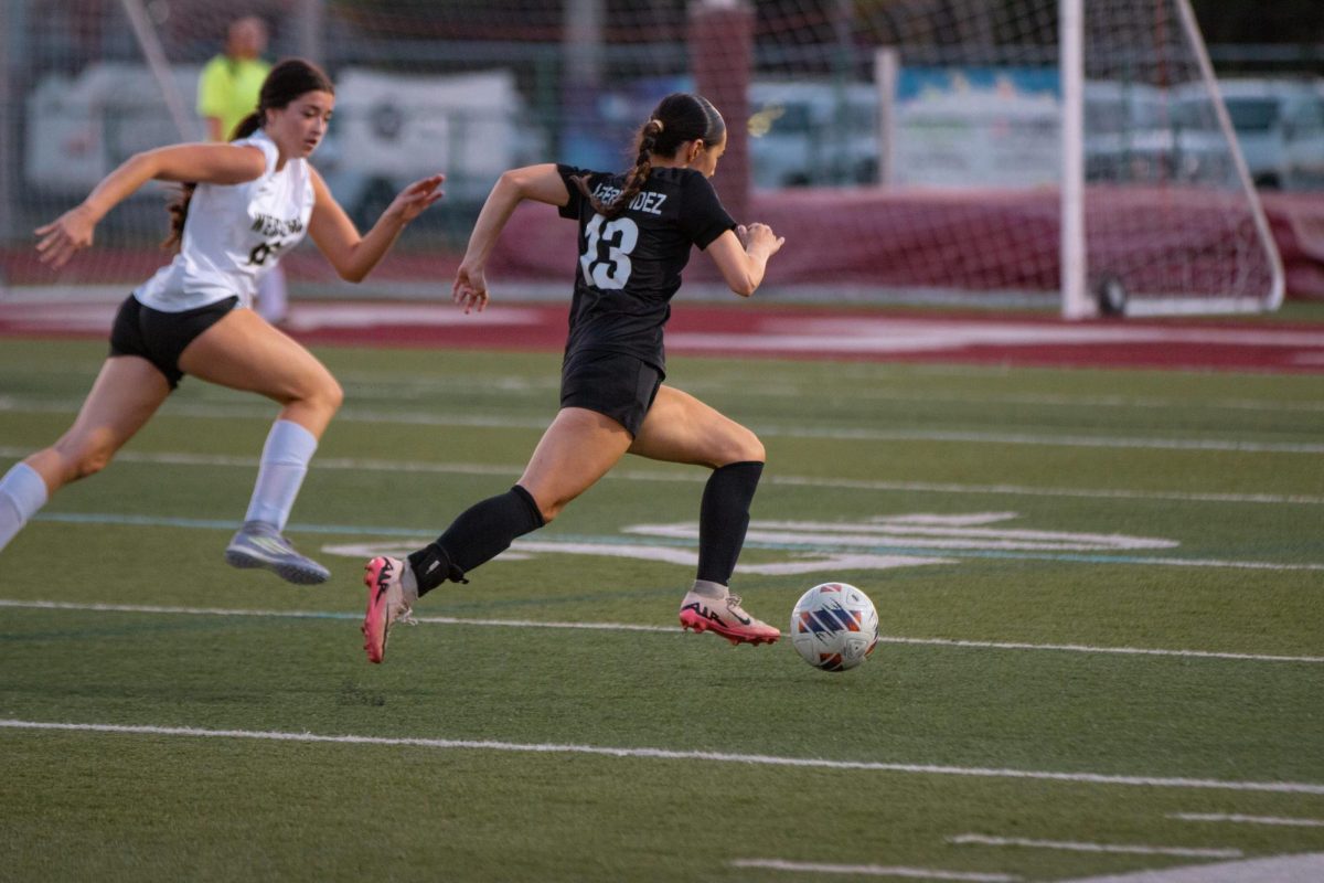 Senior Amanda Fernandez [#13] as she runs with the ball attempting to make a goal for the Lady Jags against Western High School.