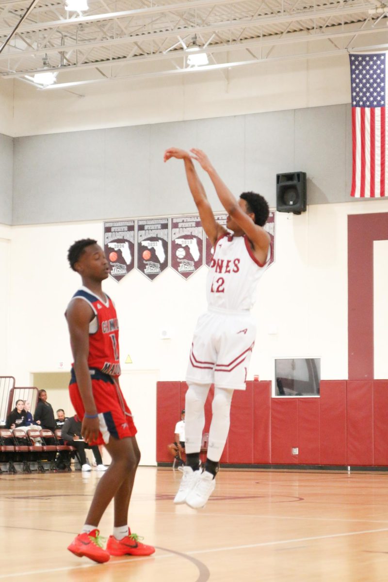 Freshman Aaden Labadie [#12] as he shoots the ball in a three-point attempt for the JV Jaguars basketball team.