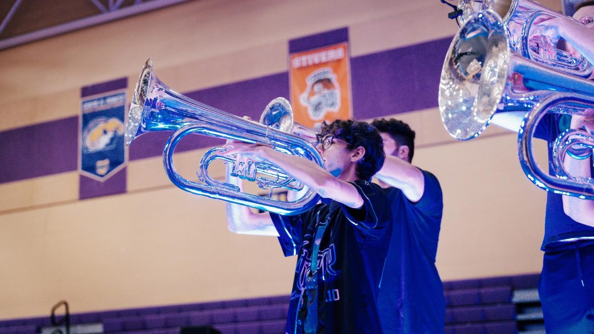 Aden Carnero carrying his traditional instrument, a baritone, and holding it with pride as he continues to play with the rest of his team.