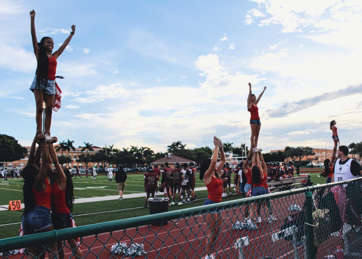 The Lady Jags cheer team holds their fliers in the air at the varsity football USA-themed home game as they cheer on the Jaguars.