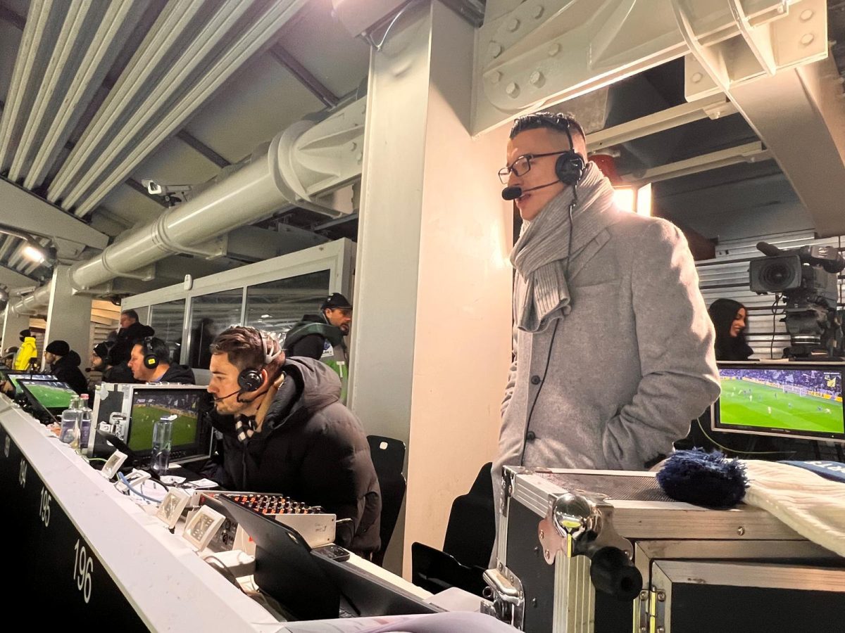  Inside the broadcast booth, Chris Wittyngham (centered right), provides live match coverage, engaged in the preparation, timing, and delivery required of professional soccer commentary.