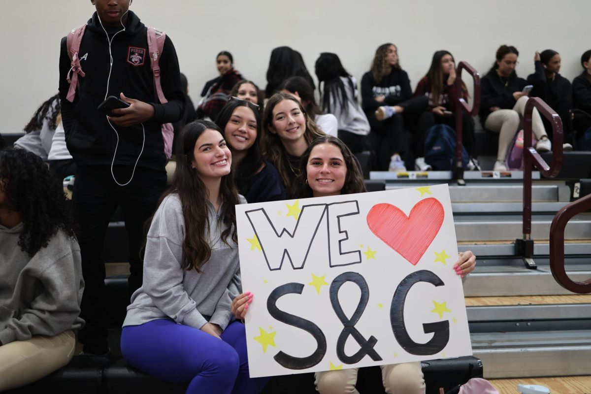 Charter students spectate the dodgeball tournament with posters to support their favorite team. 