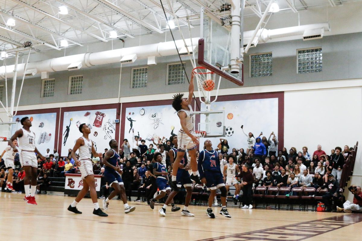 Junior AJ Starr [#1] for the Jaguars basketball team dunks the basketball during a home game.