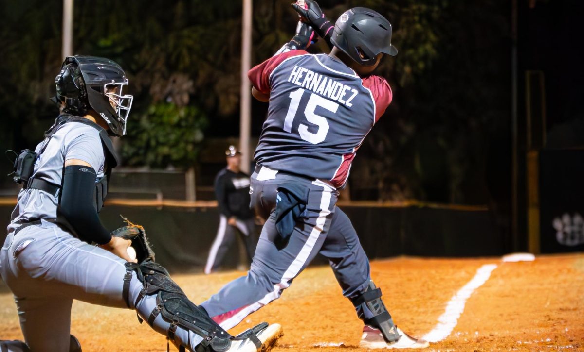 Junior Jack Hernandez swinging his bat and making contact with the ball for a single that brings in the runners to score for the Jaguars.