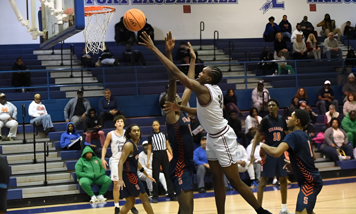 Senior Robert Guishard as he makes a layup pushing through the players guarding him.
