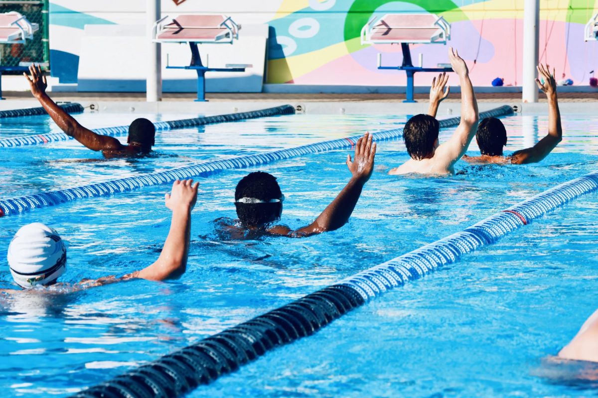 The waterpolo team hold their hands up during warmups prior to a scrimmage against each other ready to roar into the season.
