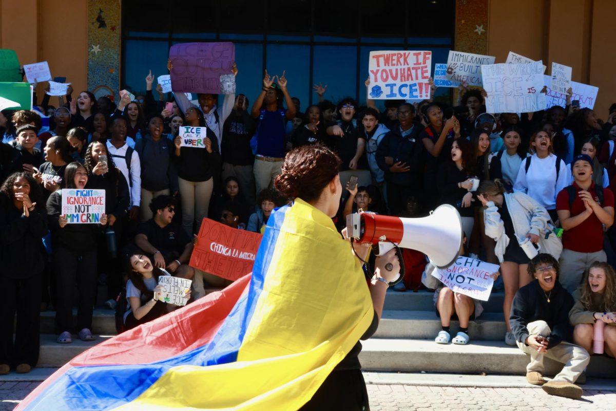 Senior Mariana Rios leads PPCHS's ICE walkout with a Colombian flag on her back. Students shout and wave signs in protest of ICE violence across the country.

