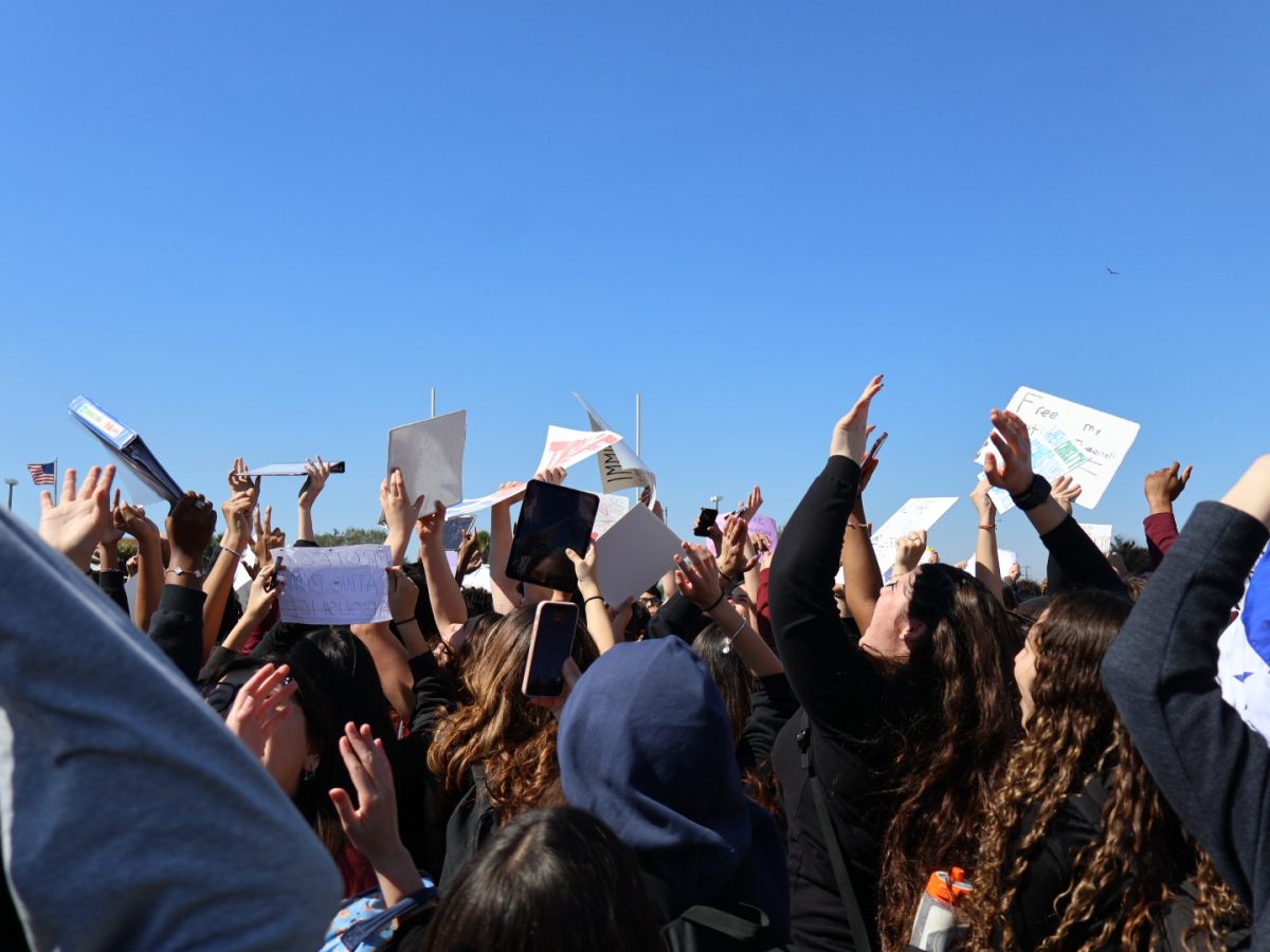 PPCHS students from every grade hold up their hands and posters in protest against ICE's presence in Pembroke Pines and in the US as a whole.
