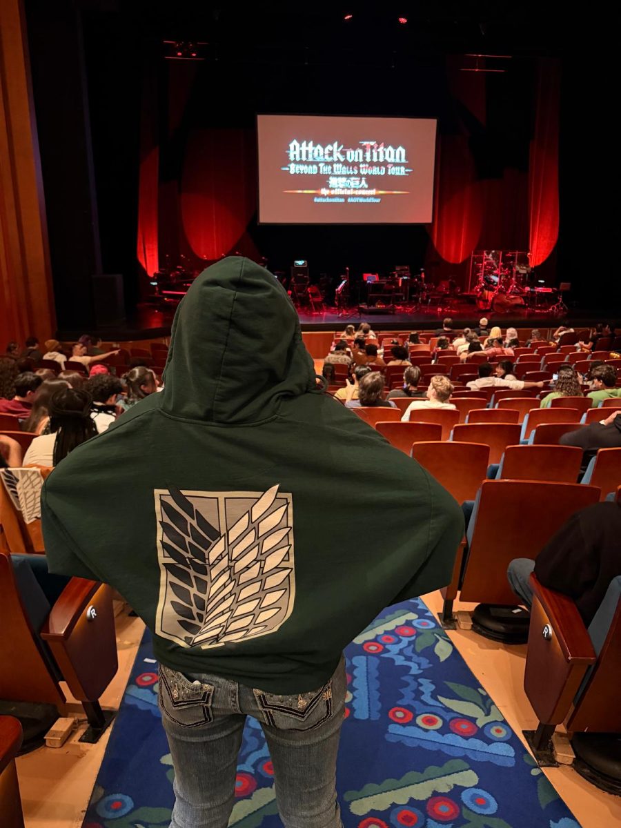 Alejandra Gomez Velasquez standing triumphantly, ecstatic to be at the Attack on Titan orchestra event. It was held in the Broward Arts center.