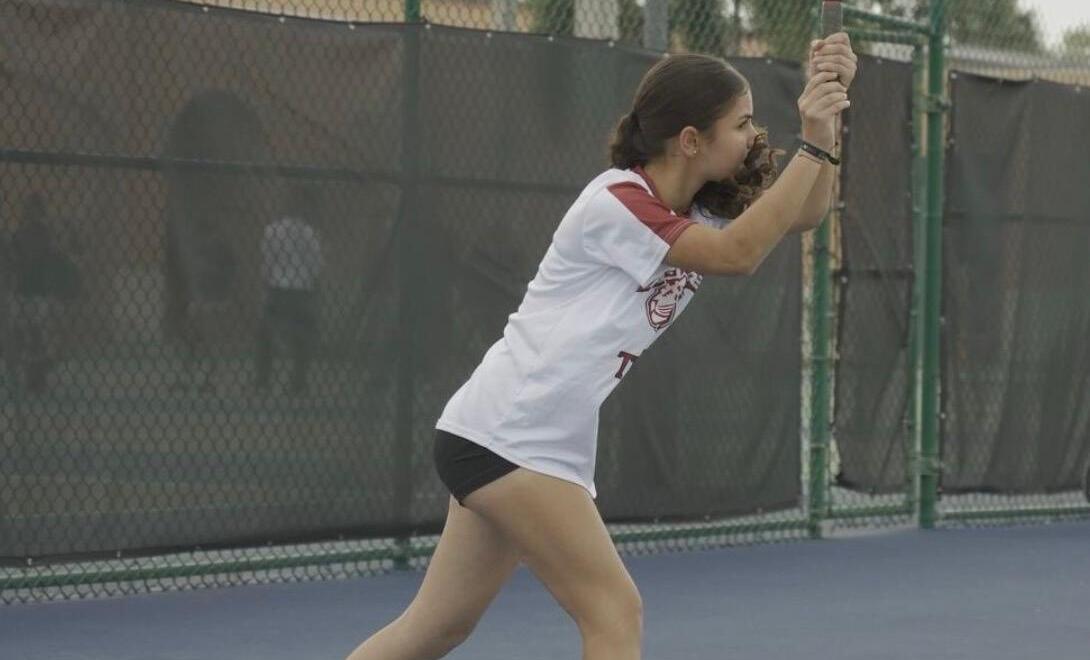 Gonzalez swinging her racket with power as her feet are set to hit the ball.