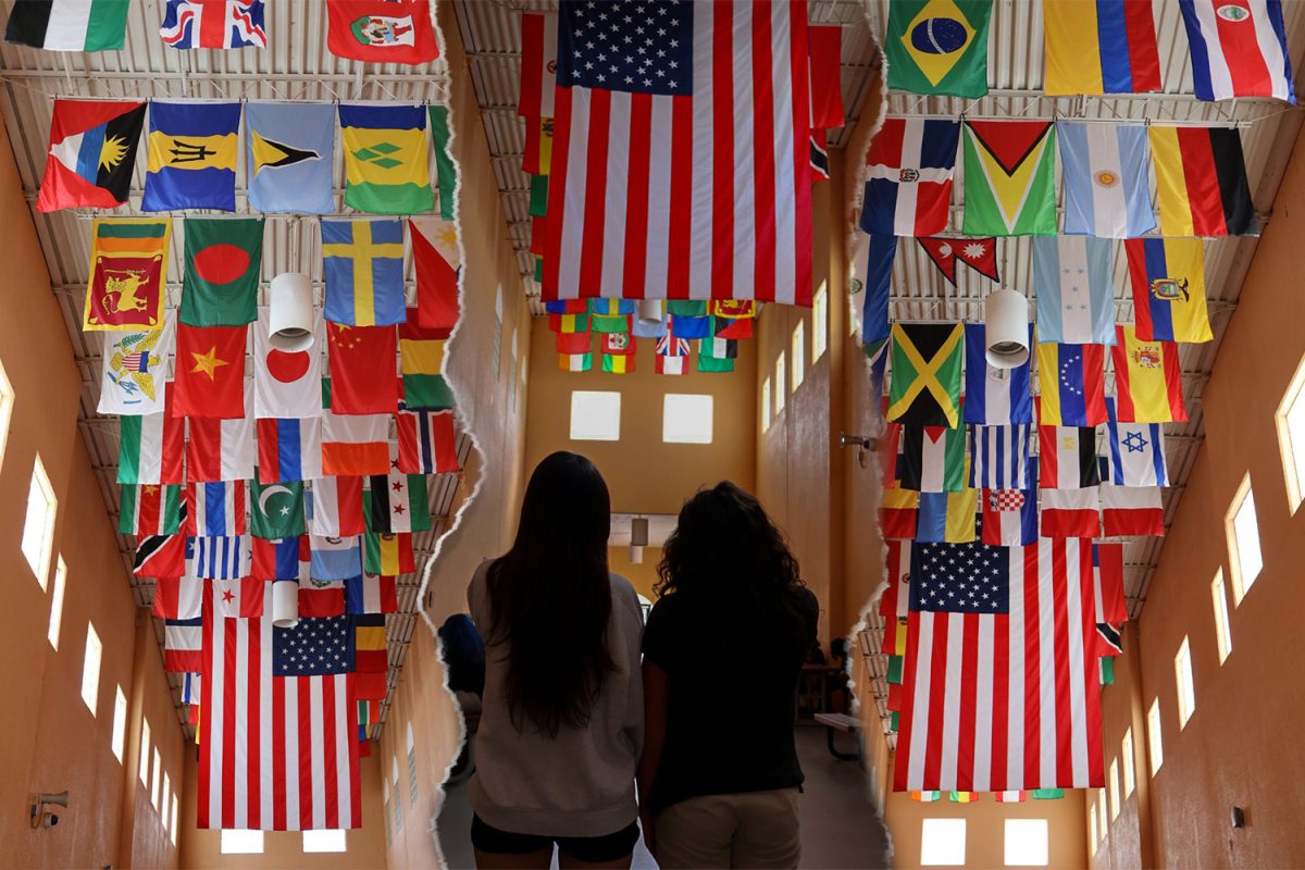 Two PPCHS students look at flags hung from the breezeway ceiling. Each flag represents students' nationalities, celebrating schoolwide diversity.