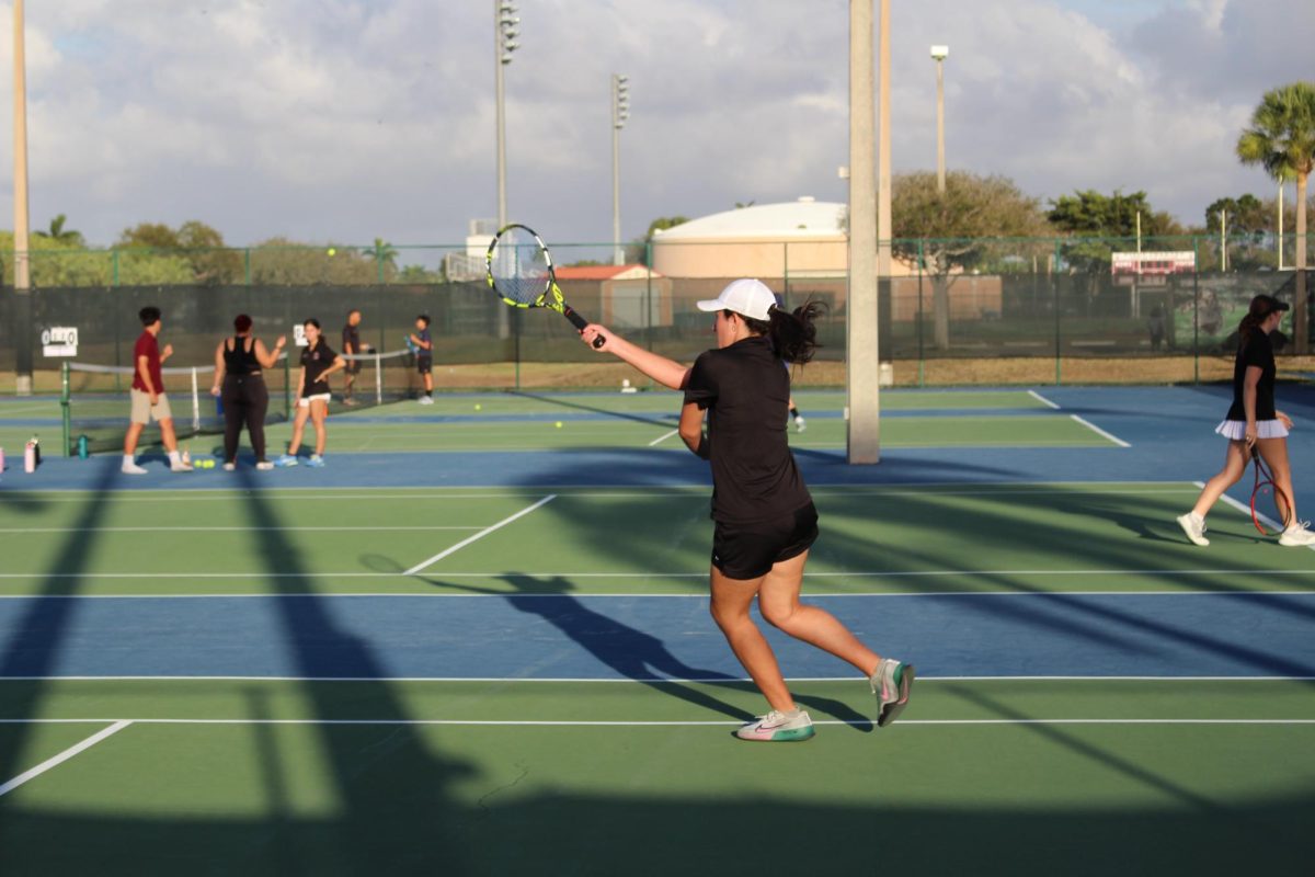 Fabiana Alejandra hitting the tennis ball with her racquet under the hot sun during a game.