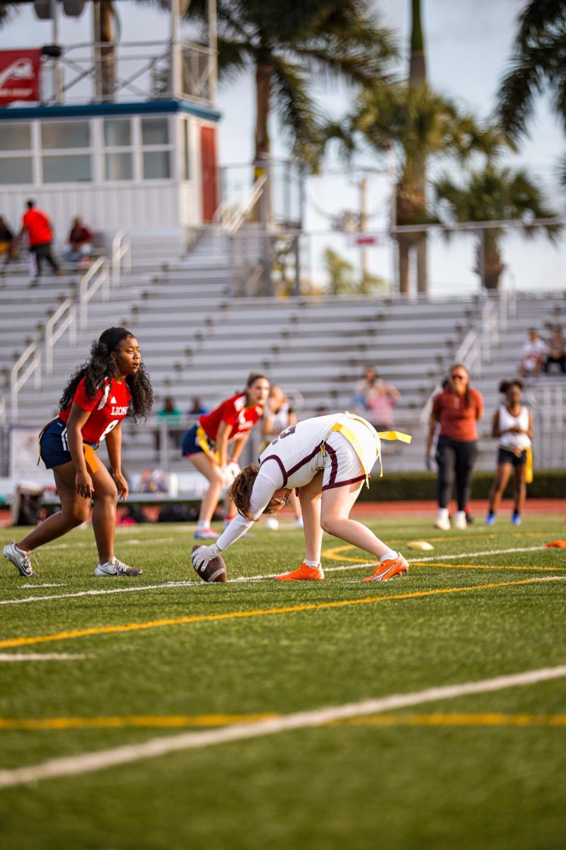 Junior corner Lucy Fishman snapping the ball to the quarterback while planting her feet in the ground to maintain a solid balance.