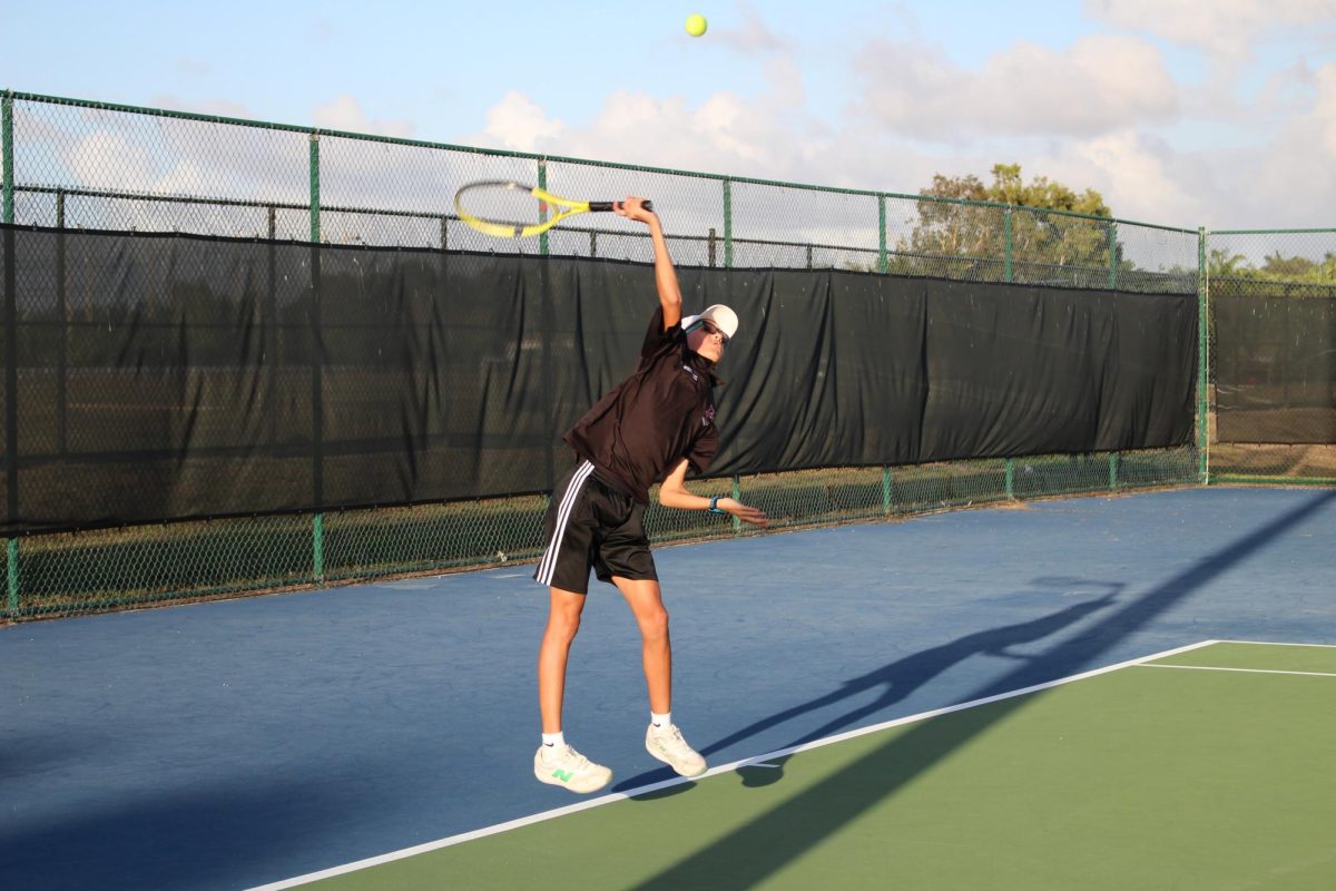Fabián Mendez as he jumps to serve the tennis ball to start the match.