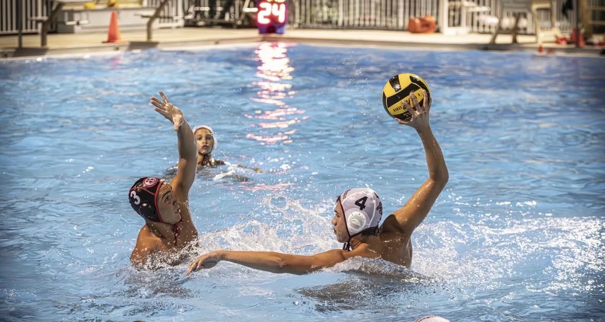 Junior Matthew Osorio (#4) using power to throw the waterpolo ball past his opponent into the goal.
