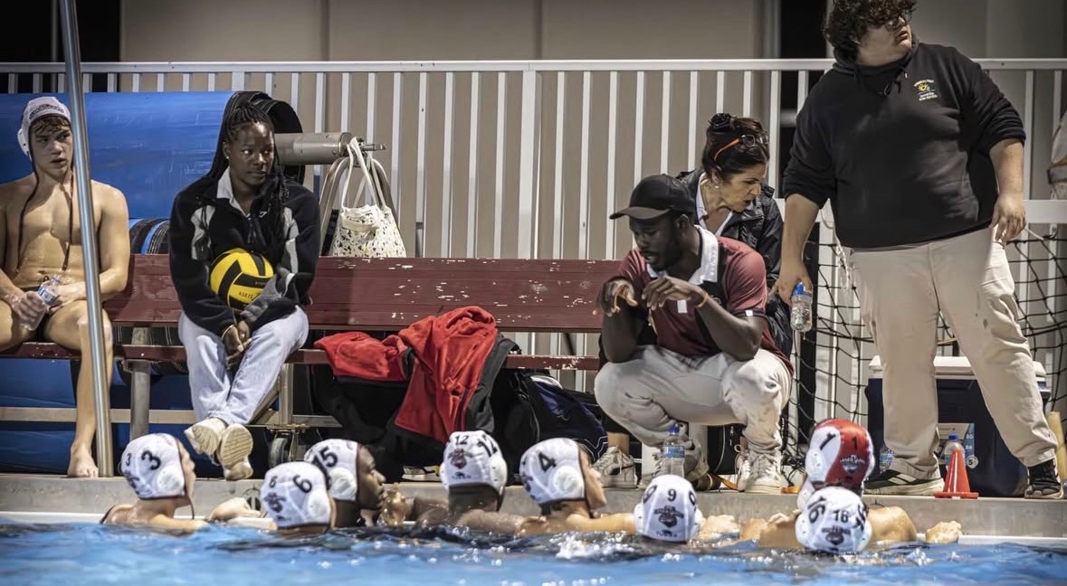 The Jaguars water polo team listening to their coach as he gives them a pre-game speech. 
