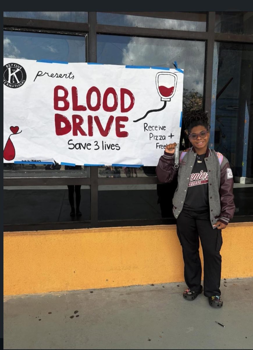 Senior Lealia Taylor next to the Blood Drive poster.