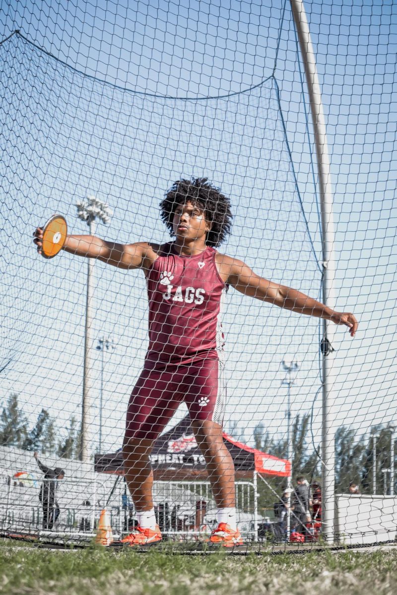 Junior Alexander Steszewski preparing to throw in the shot-put competition using power and determination.