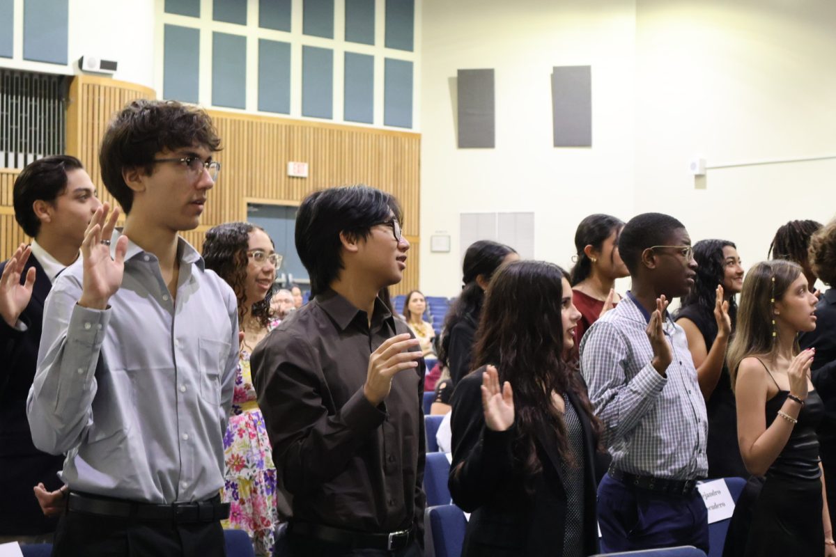 National Honor Society inductees stating as they read the pledge off of the projector to join.