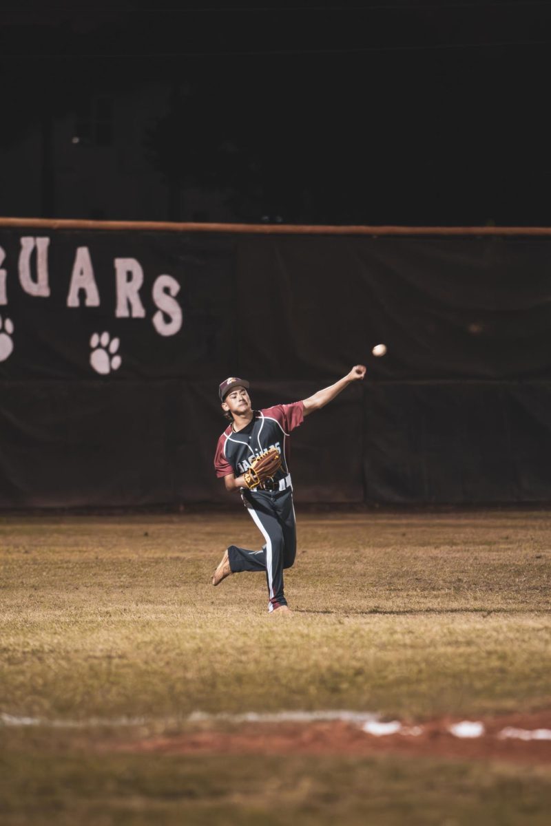 Sophomore Luciano Bello throwing the ball from left field to make the play at home.