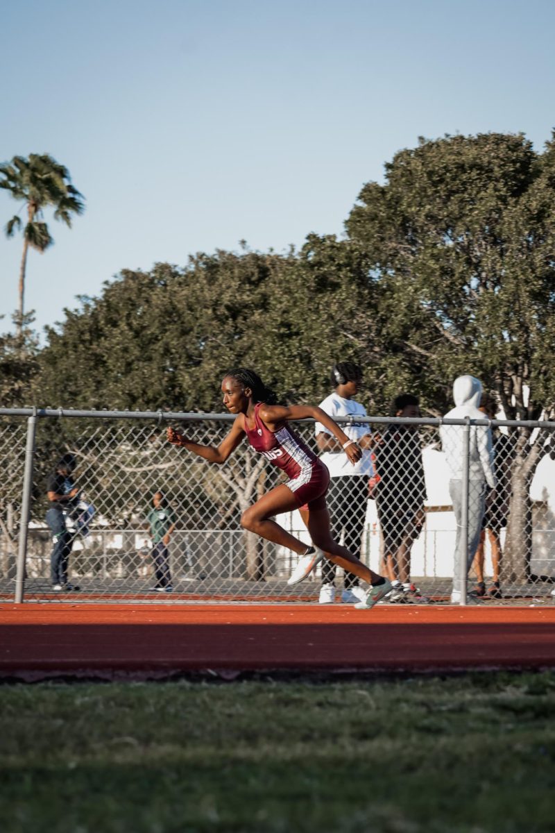 Senior Sarah Rogers sprinting at a track meet aiming to get first place. With each step; she uses power, confidence, and speed.