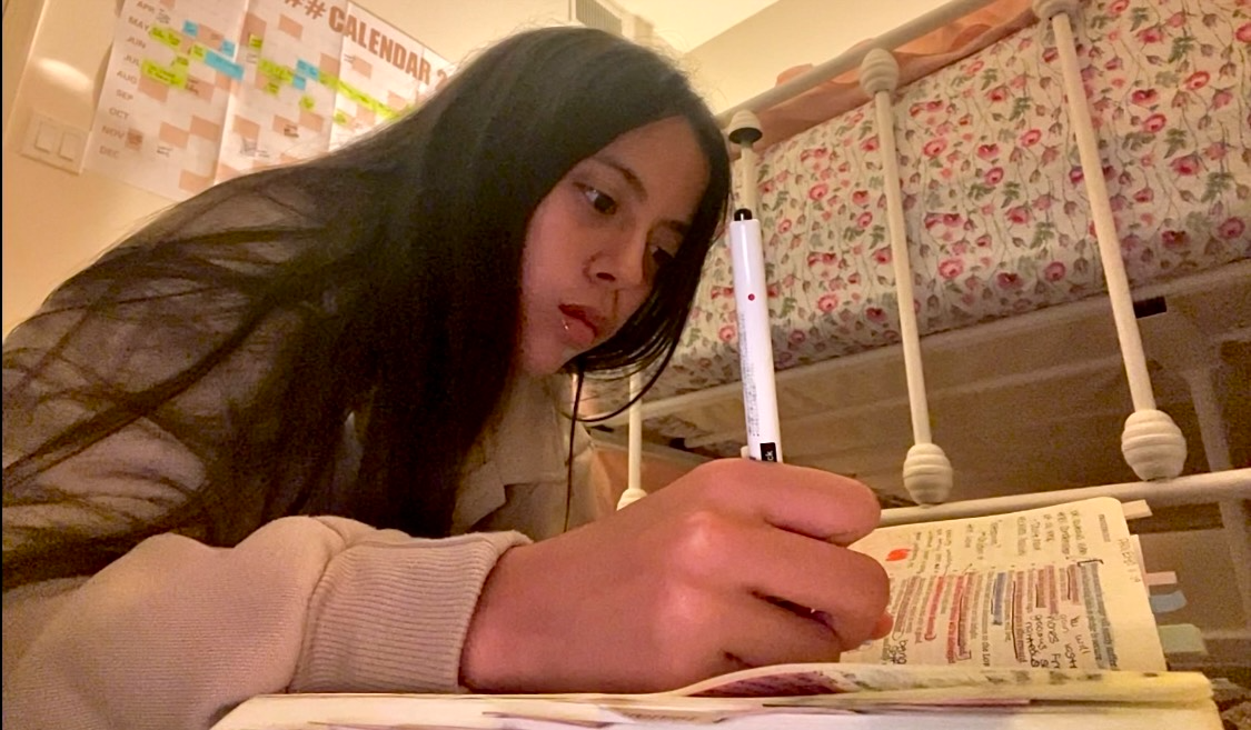 Loraine Sanchez Figueroa sits on her floor as she reads and writes in her Bible as she continues to try and gain more wisdom to help others understand the Bible’s teachings too.