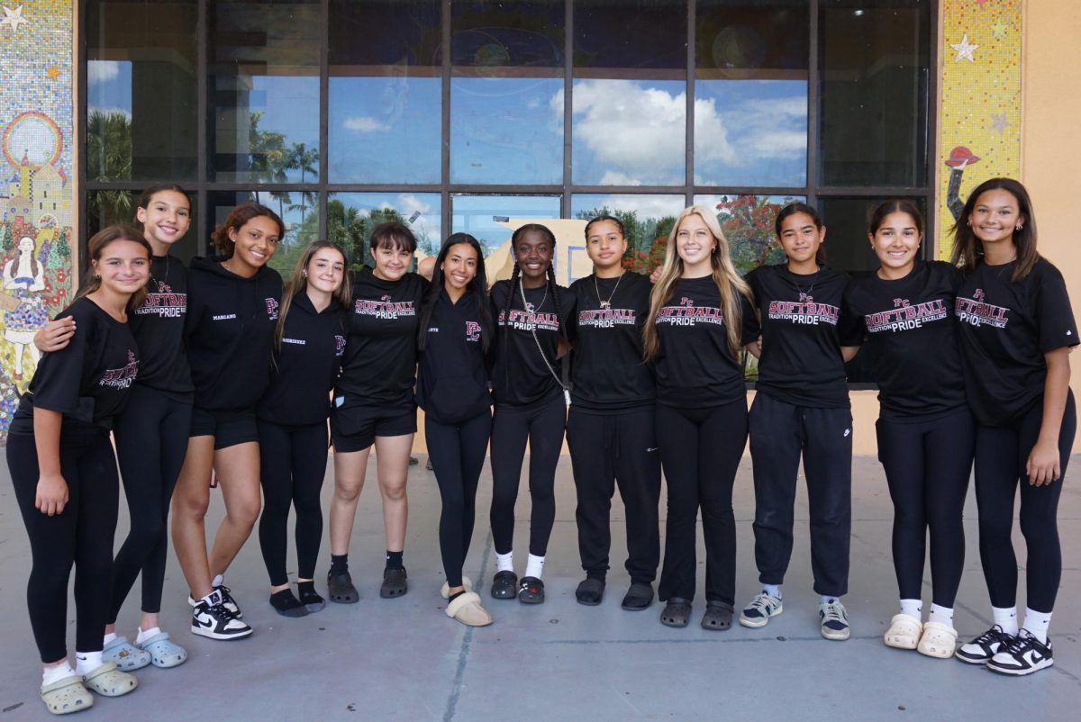 The Lady Jaguars softball team smiles at the River of Grass ahead of the state semi-finals competition.