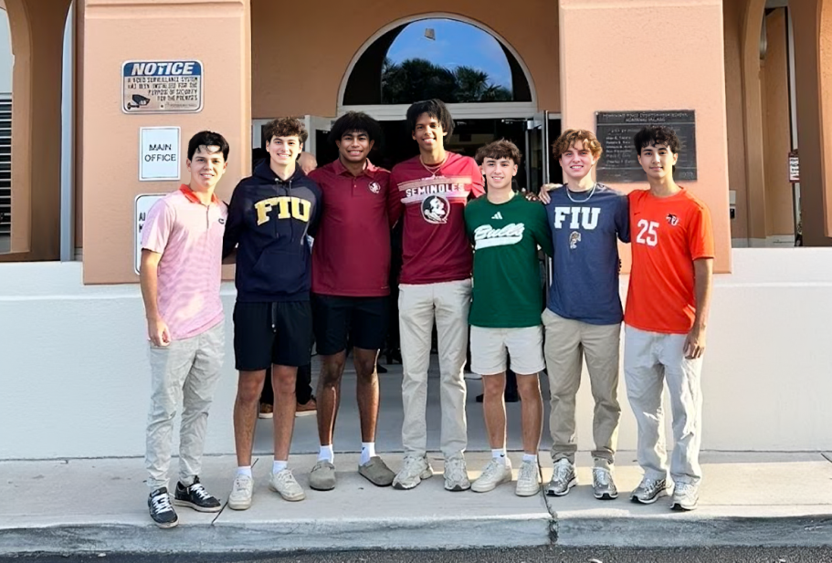 PPCHS seniors standing together with their shirts displaying what college they will attend after high school. 