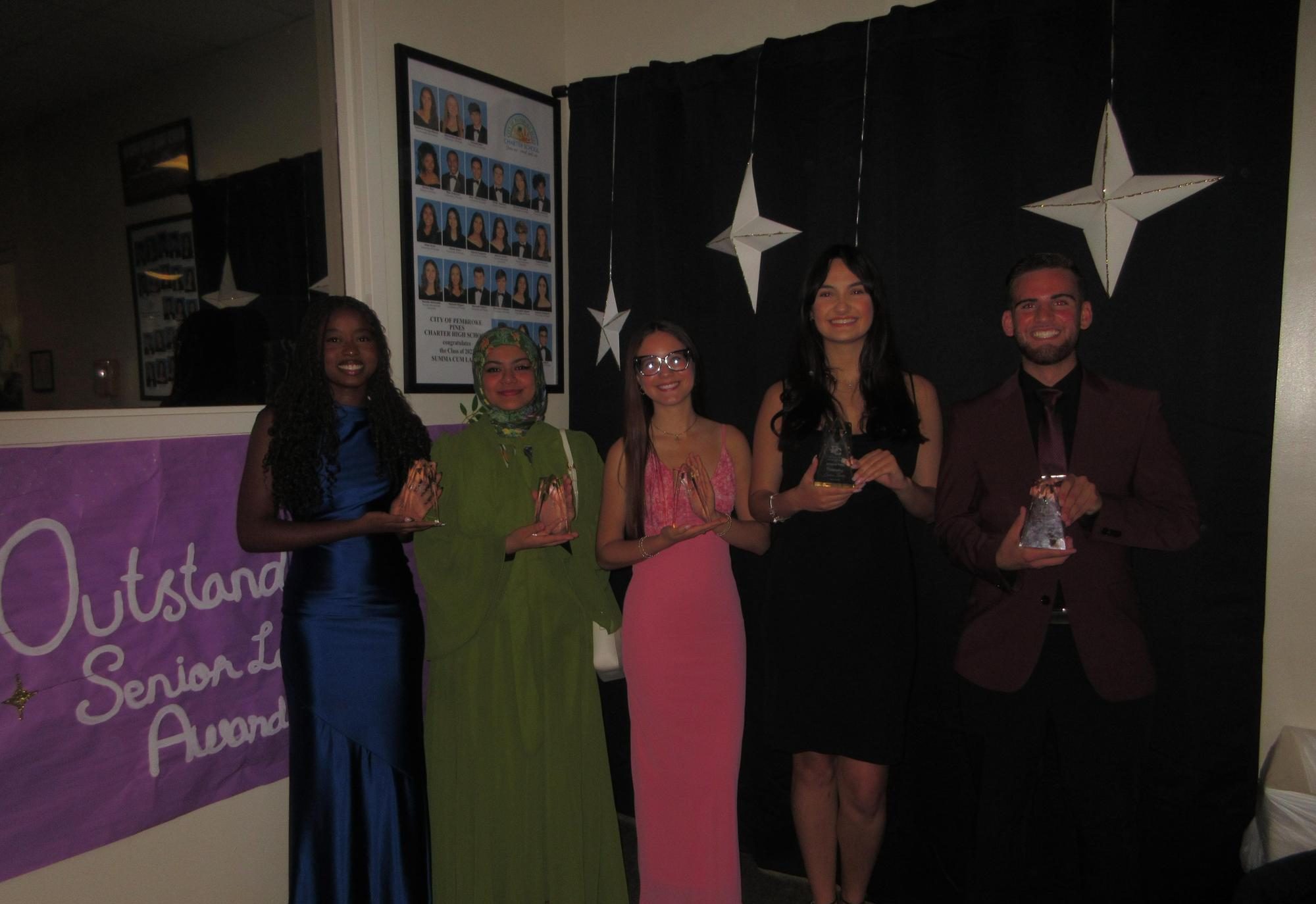 (left to right) Robertzsa Joseph, Asiya Mohammed, Janeyliz Baez, Julianna Perez, and Ryan Perez smile and hold their trophies, honoring their contributions to the school community.