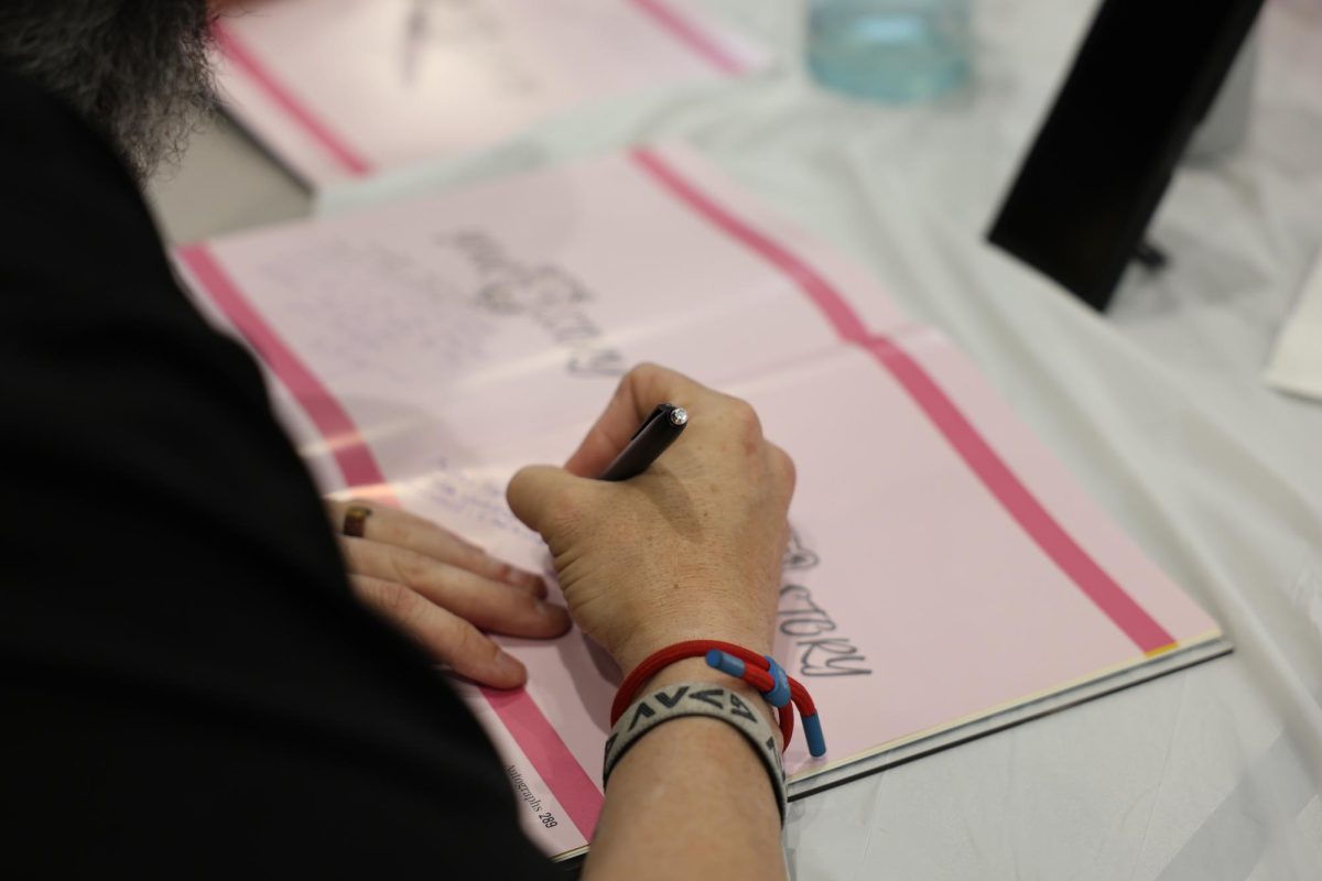 A senior signs a peer's yearbook, leaving a heartfelt note for friends.
