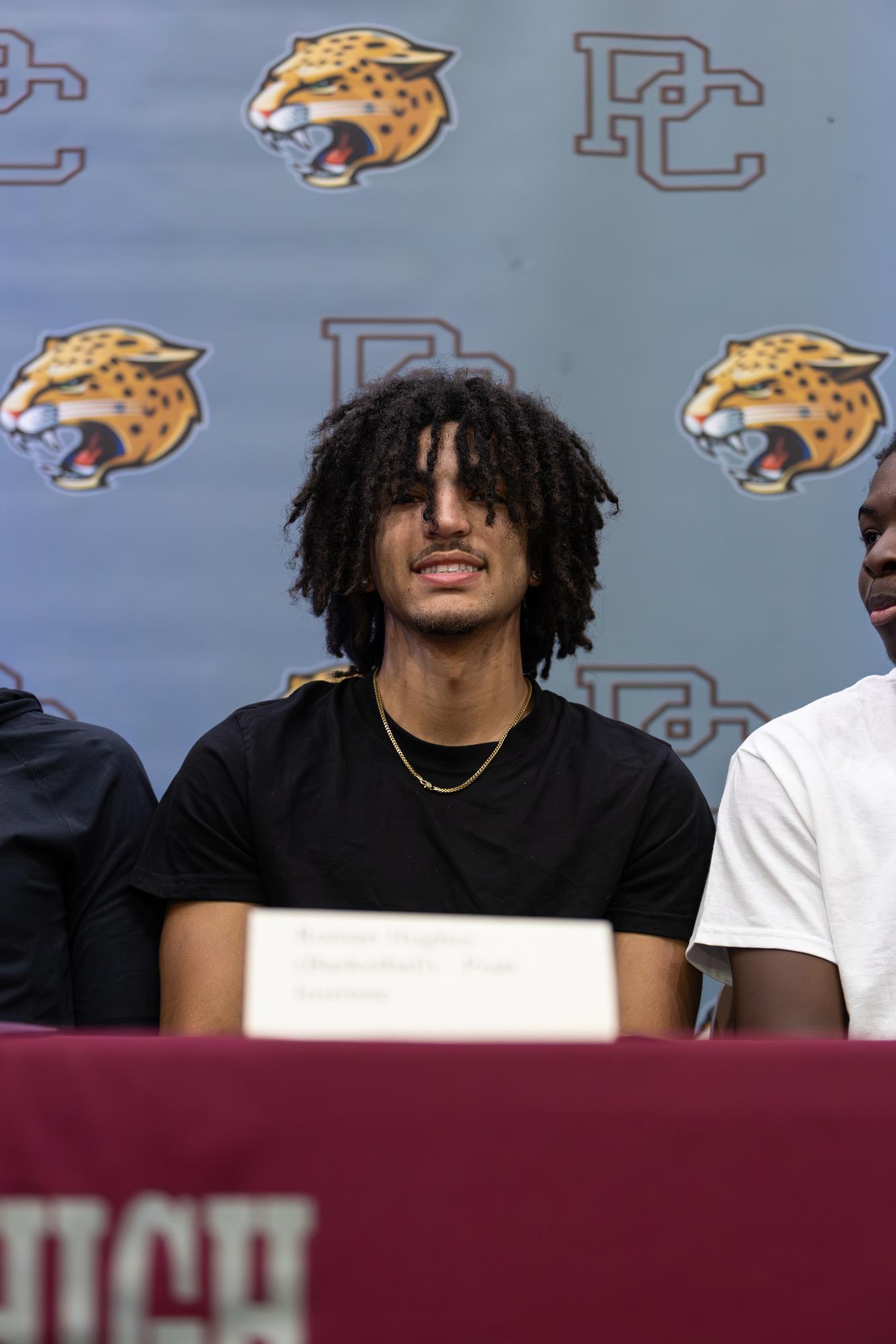 Senior Roman Hughes smiles at the camera on signing day after signing his letter of intent. 